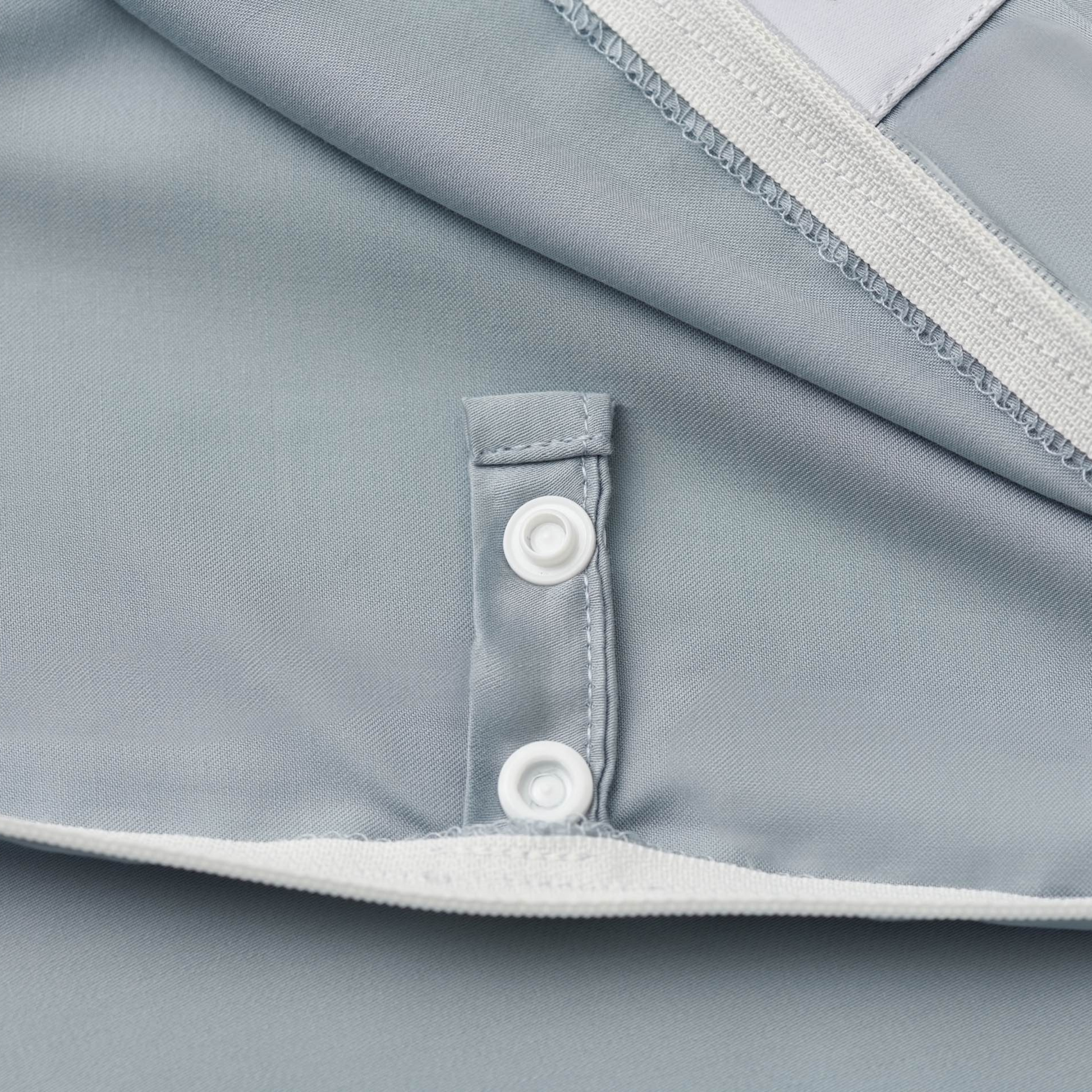 Close-up of a blue 100% Tencel™ Lyocell fiber duvet cover with a zipper and button detail