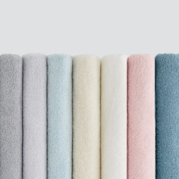Row of textured fabric swatches in various pastel colors on a light gray background
