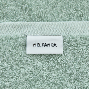 Green towel with a white label displaying 'NIELPANDA' on a textured fabric background.